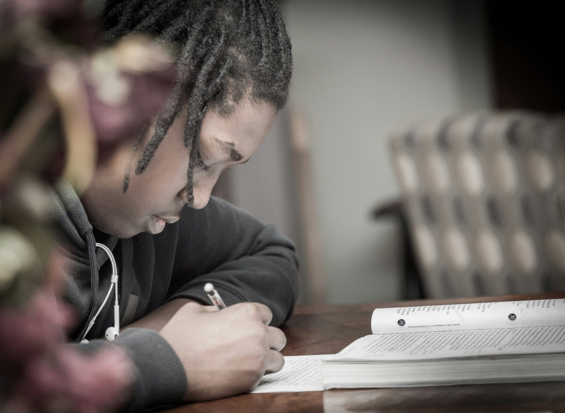 A student concentrating while writing in a notebook