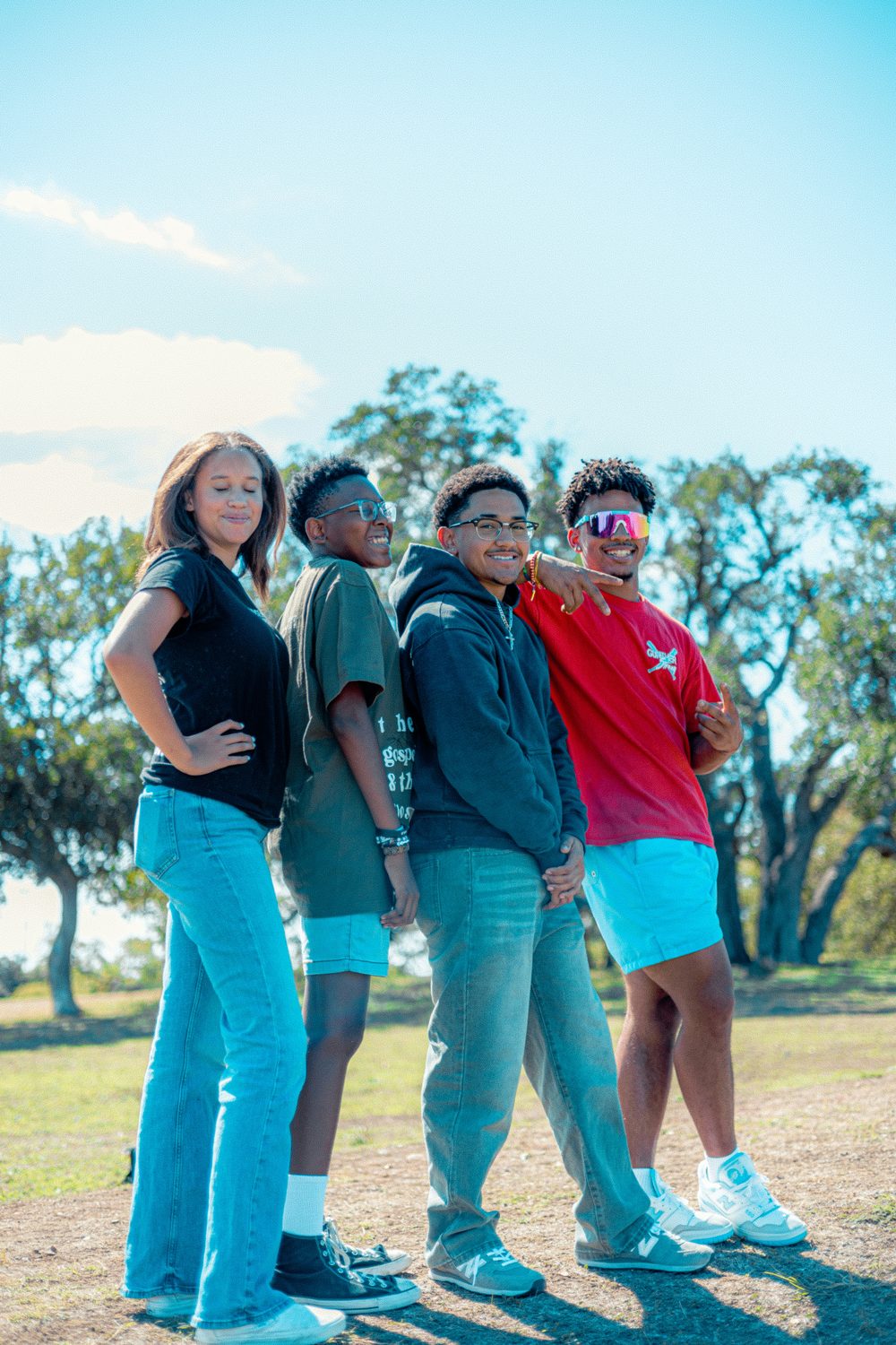 A group of teens posing together in a sunny park